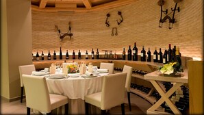 Een restaurant met een bakstenen muur, houten plafond en wijnrekken.