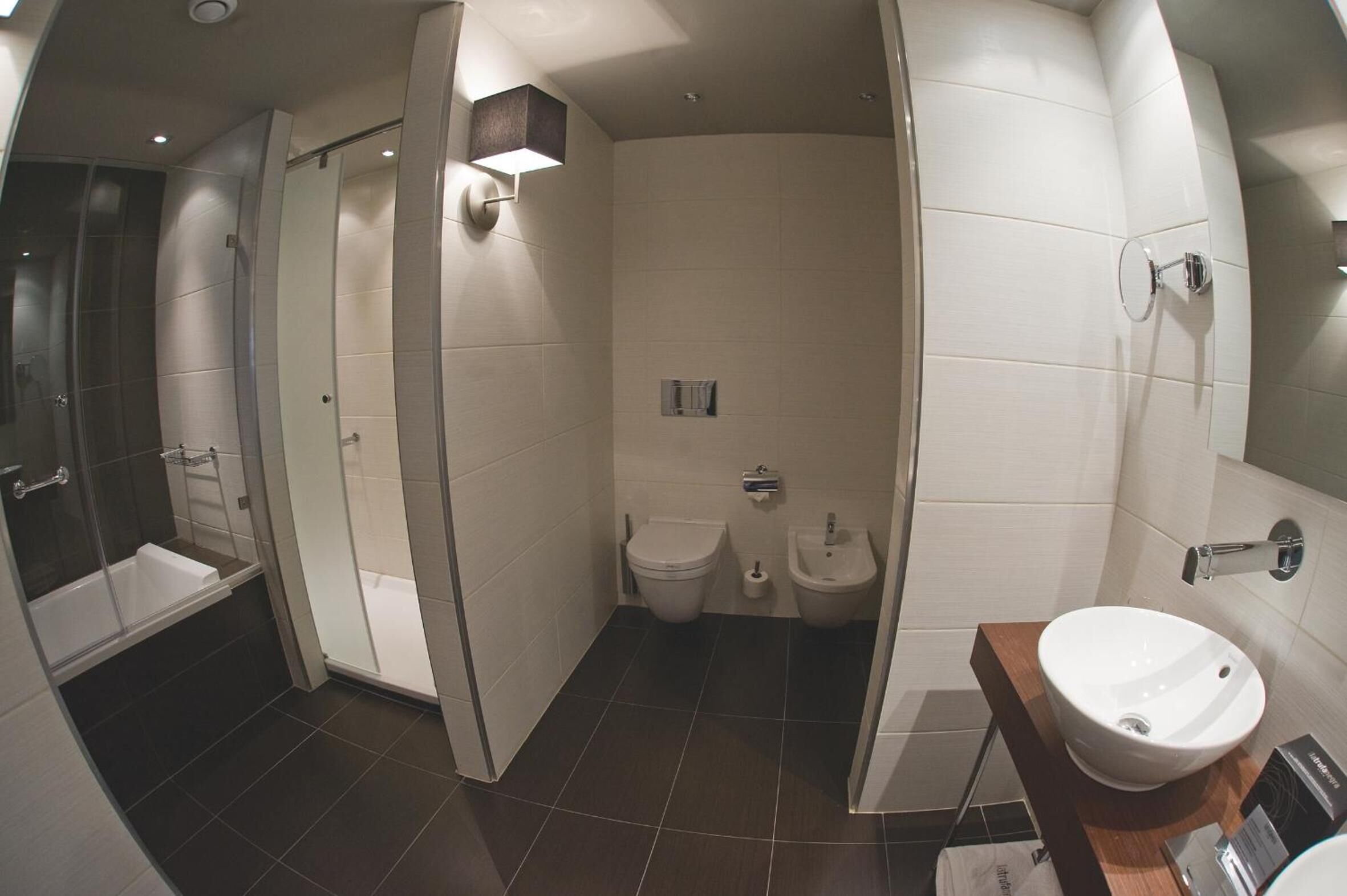 Un baño moderno con ducha de vidrio, bañera, inodoro y lavamanos.
