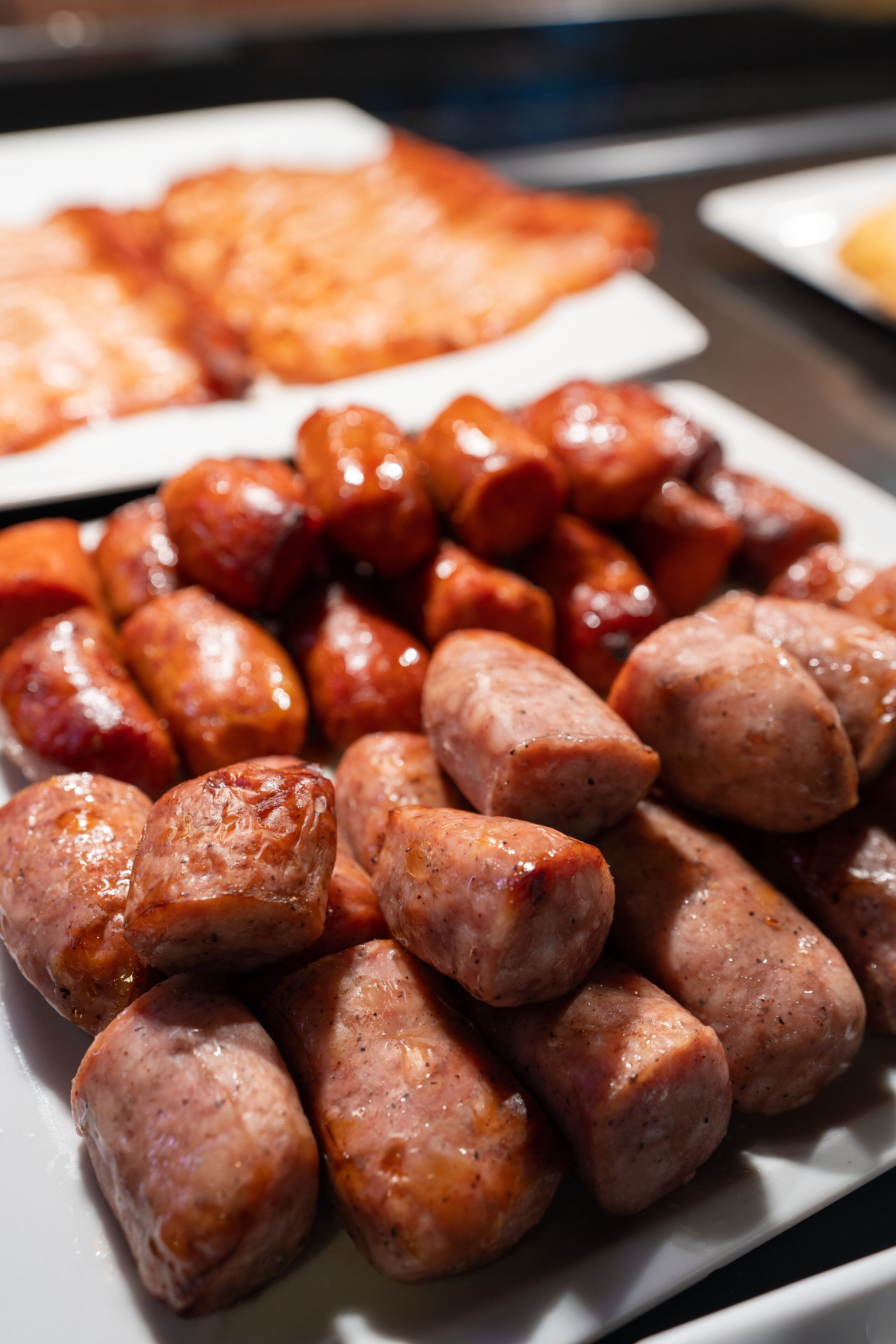 A plate of cooked sausages and a plate of toast.