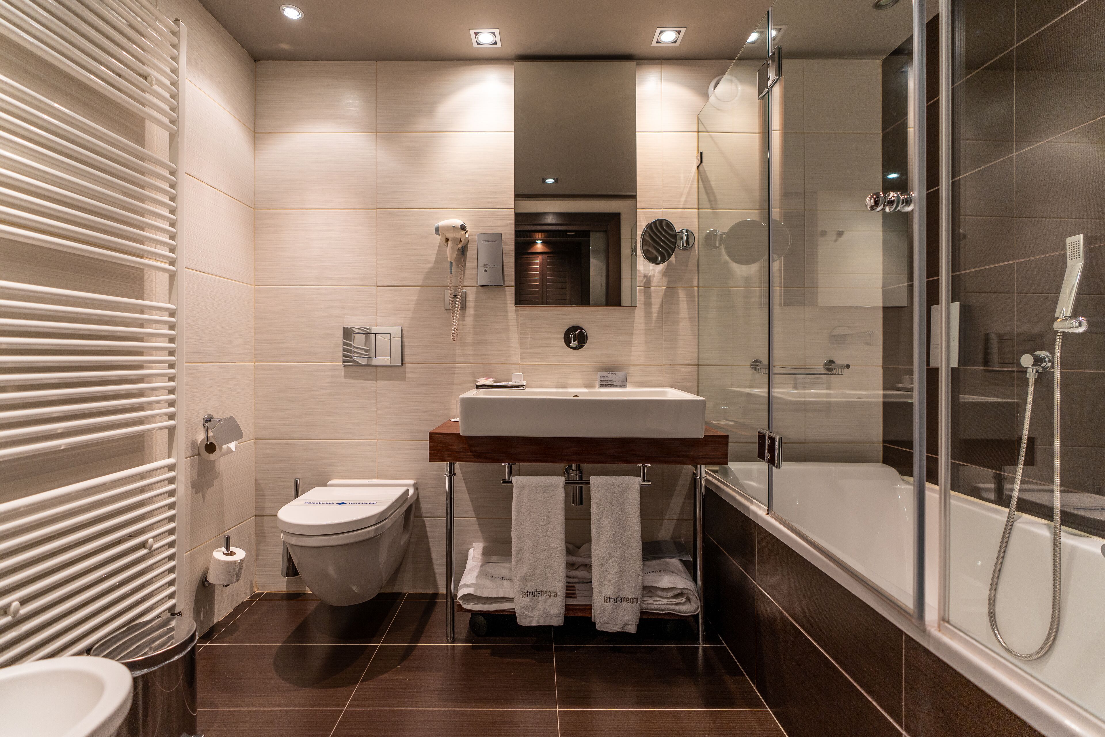 A modern bathroom with a toilet, sink, and shower.