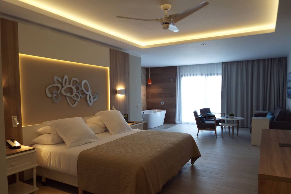 Une chambre d’hôtel moderne, dotée d’un grand lit, d’un bureau, d ’une chaise et d’un canapé.