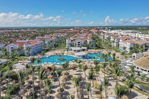 A resort with multiple buildings, a central swimming pool, and palm trees. - Bahia Principe Escape Ambar - Adults Only - All Inclusive (Punta Cana)