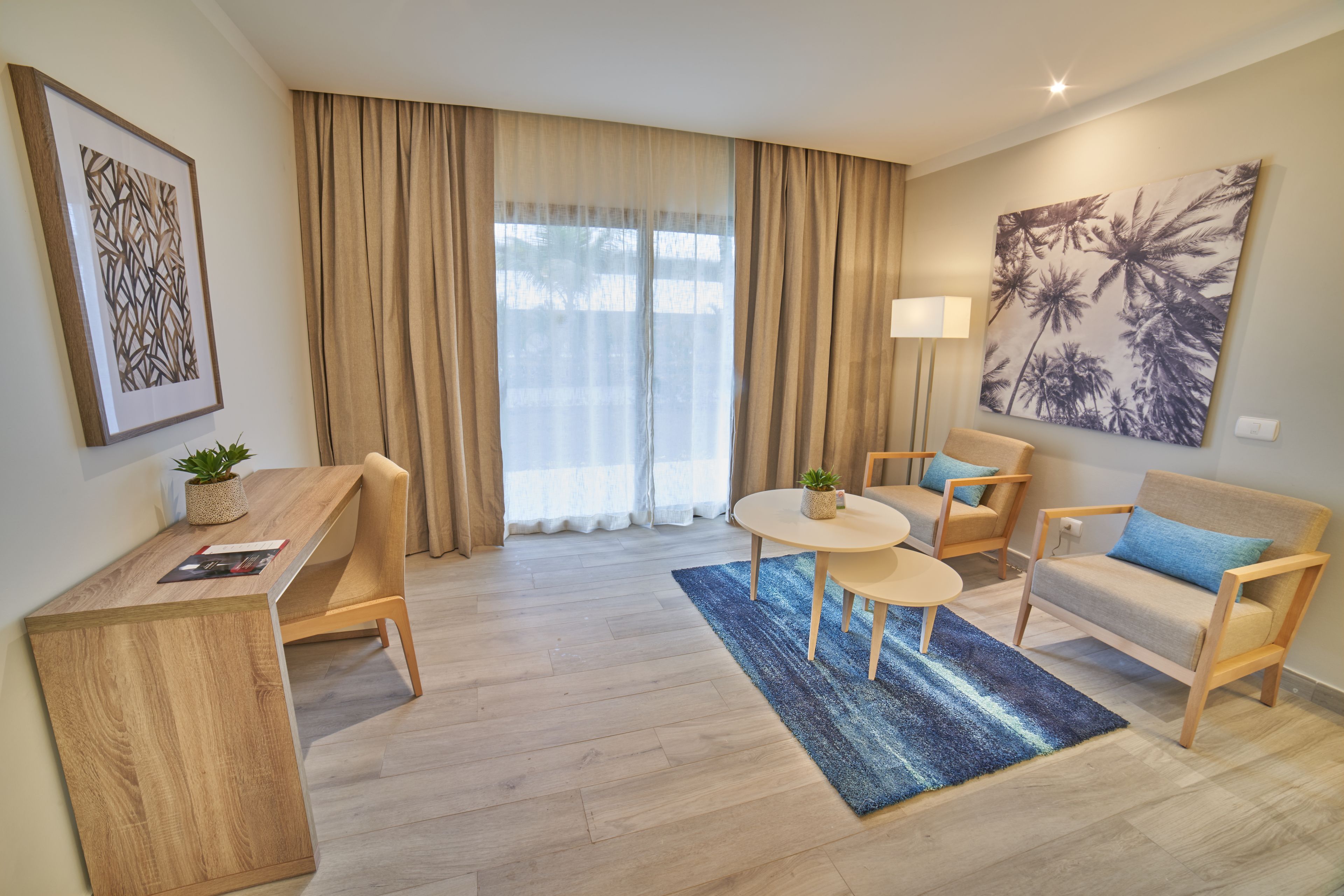 Ein modernes Wohnzimmer mit einem Holztisch, zwei Sesseln, einem Sofa und einem Couchtisch.