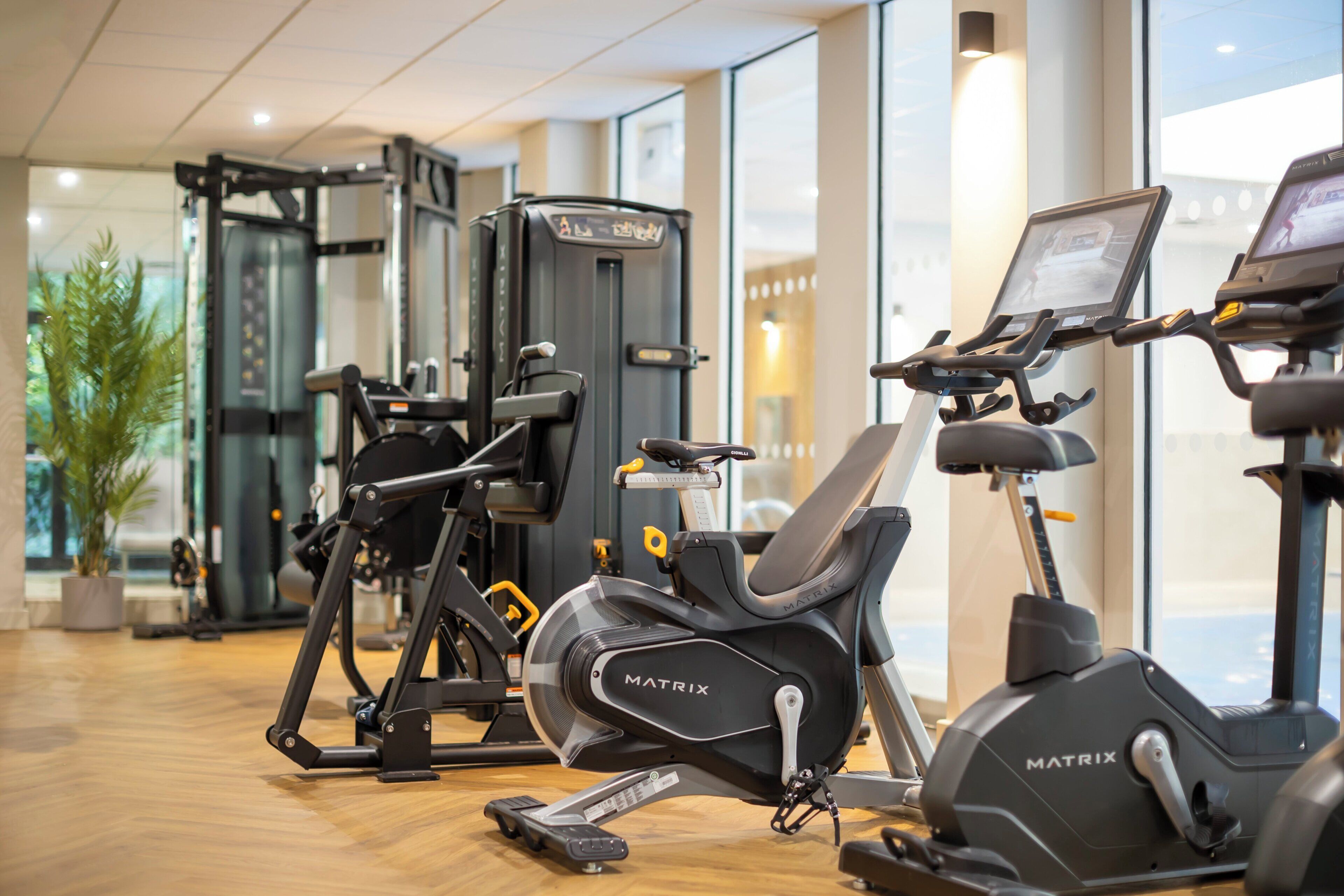 Un gimnasio con bicicletas estáticas, cinta de correr y máquinas de pesas.