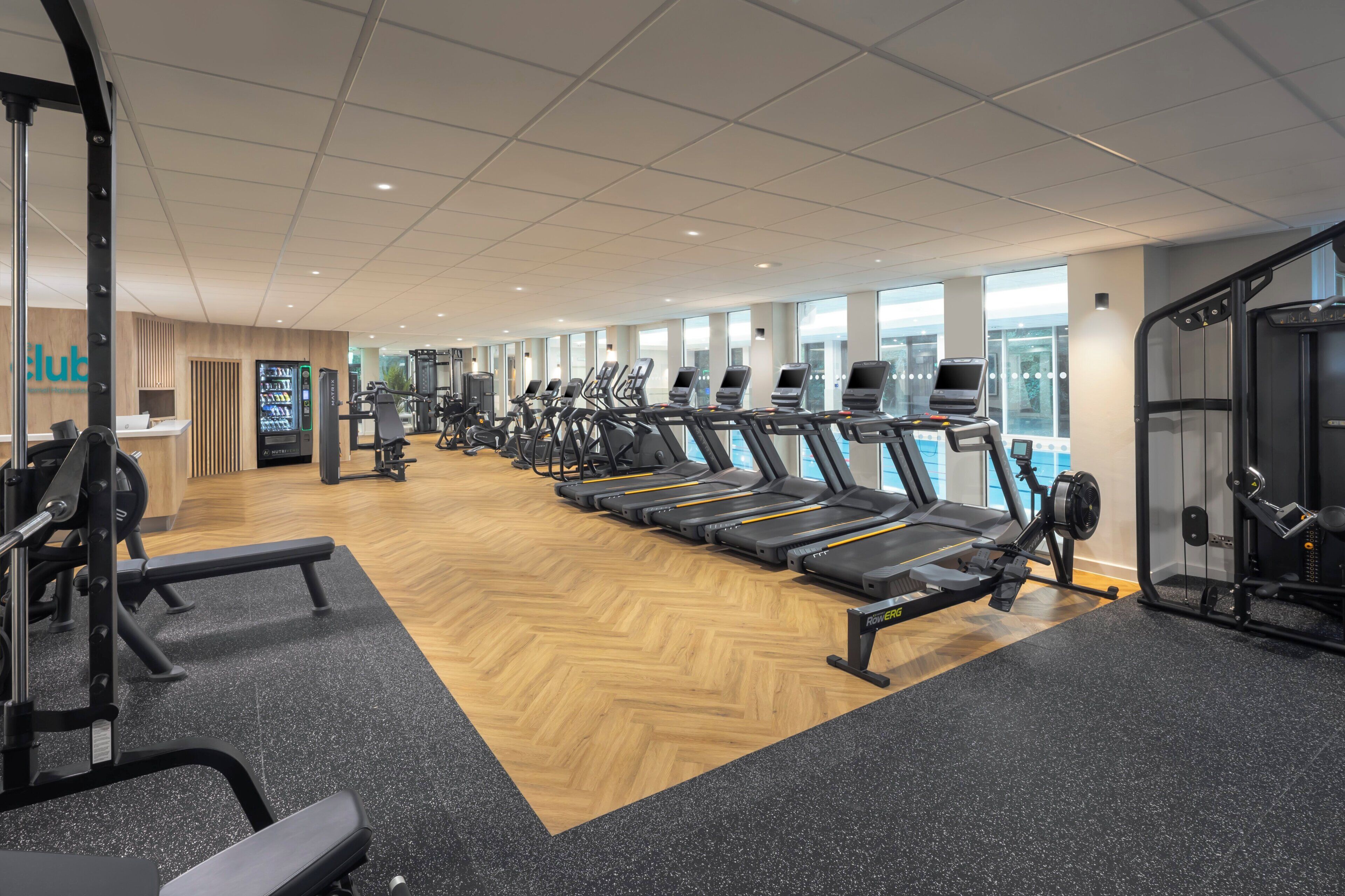 A gym with treadmills, weight machines, and a reception area.