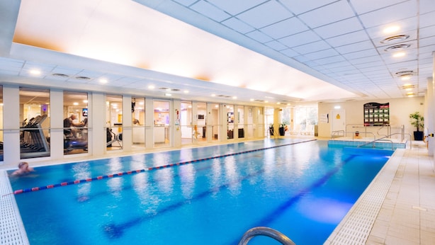 An indoor swimming pool with clear lane dividers, a tiled floor, and a ceiling with recessed lighting. - Holiday Inn Hemel Hempstead M1, Jct. 8 by IHG (Hemel Hempstead)