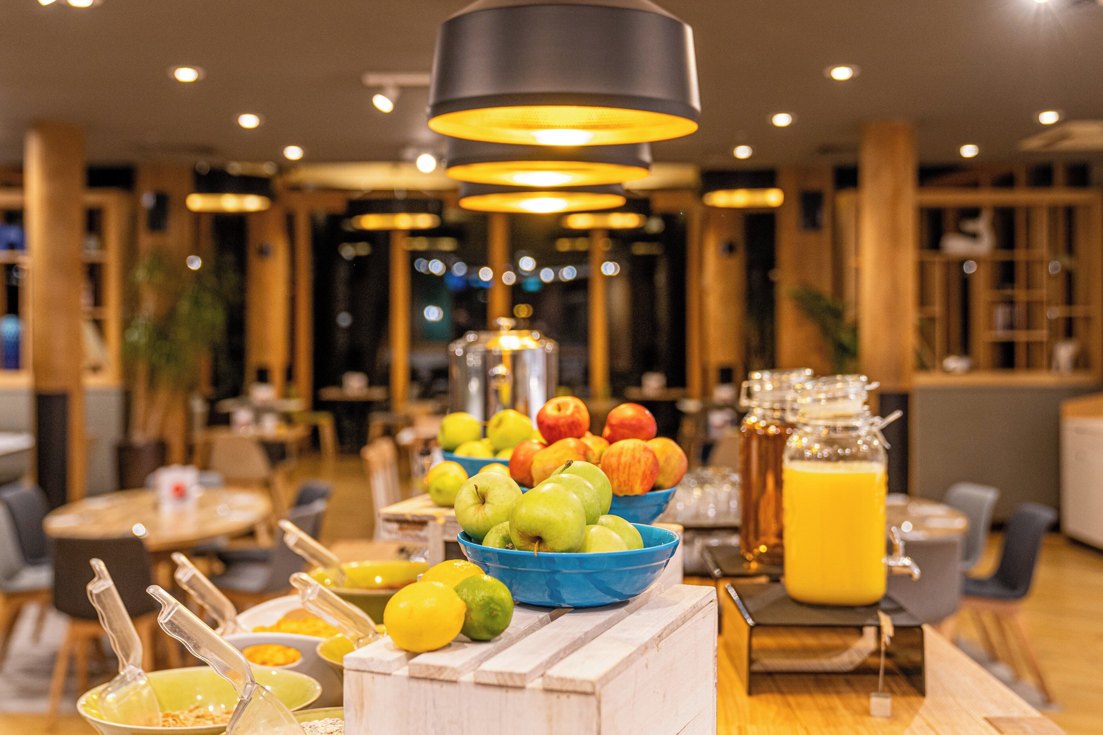 A breakfast buffet with fruits, beverages, and breakfast items.