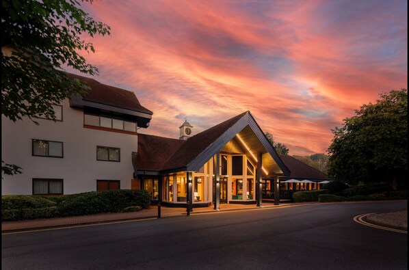 A hotel with a prominent clock tower, large windows, and a covered outdoor area. - Holiday Inn Hemel Hempstead M1, Jct. 8 by IHG (Hemel Hempstead)