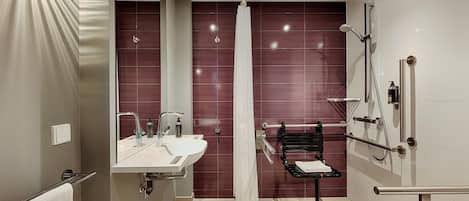 Un baño moderno con tocador, ducha y perchero.