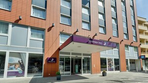 A hotel with a prominent 'Premier Inn' sign, large windows, and a modern brick facade.