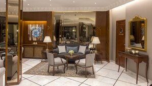 A well-lit living room with a sofa, two armchairs, a coffee table, and a console table with lamps. - Vardar Palace Hotel - Special Class (Istanbul)