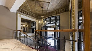 A grand interior with a marble staircase, ornate ceiling, and large windows with intricate designs. - Vardar Palace Hotel - Special Class (Istanbul)
