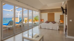 Quarto espaçoso com grande porta de vidro deslizante que dá para uma varanda com piscina e espreguiçadeiras.