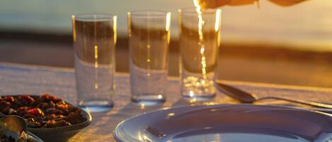 A table set for a meal with glasses, a bowl of salad, and a plate.