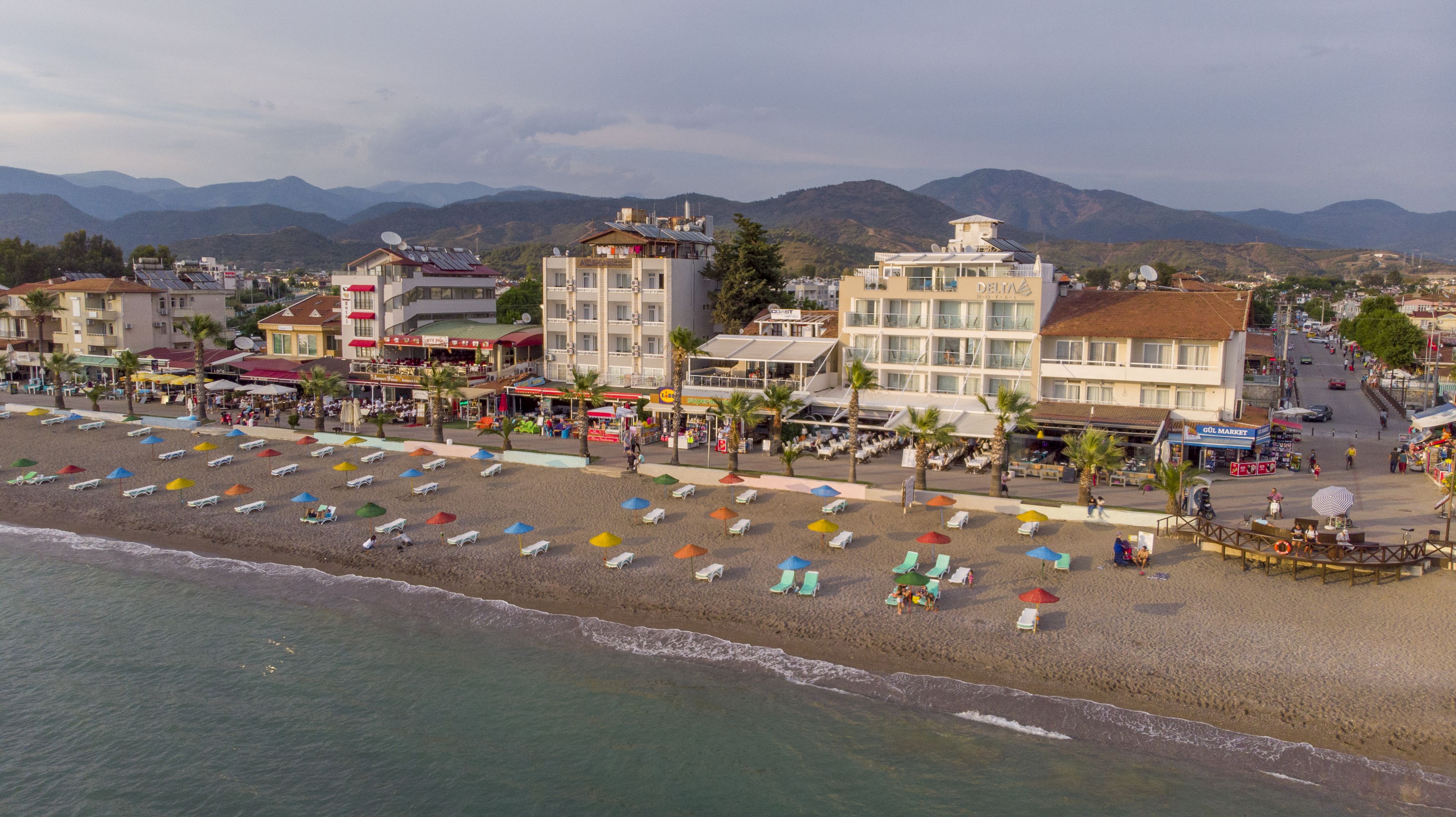 Un hôtel en bord de mer, avec plusieurs étages, situé directement sur la plage et offrant une vue sur la mer.