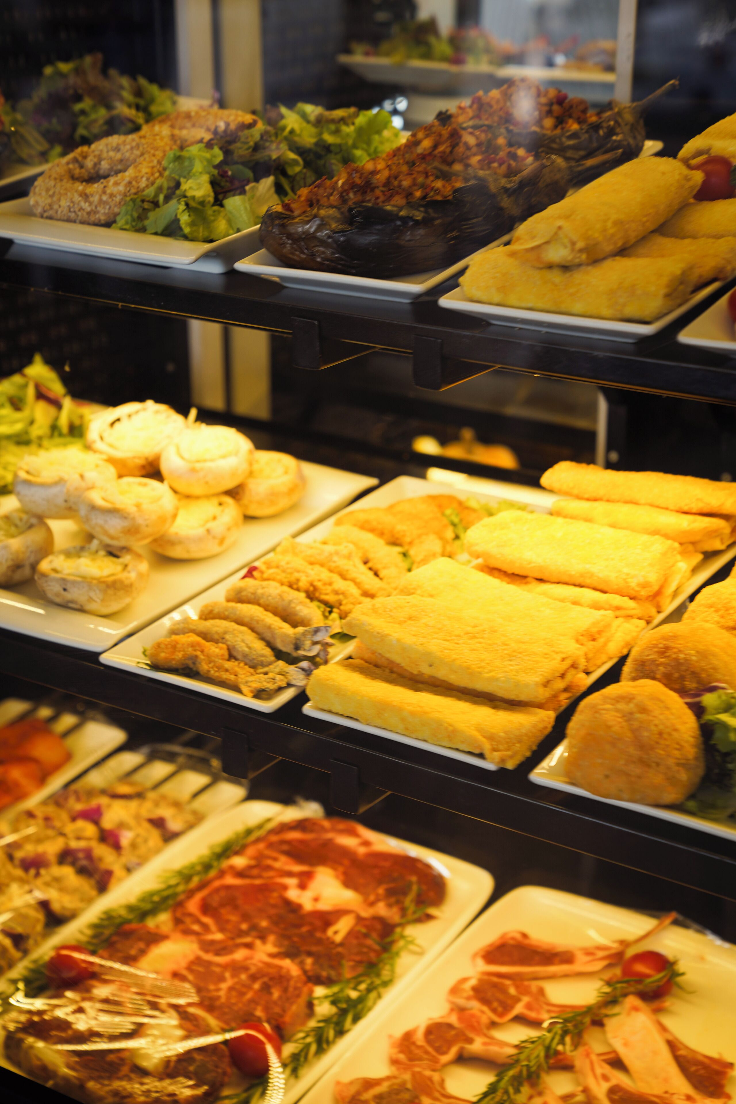 Un buffet proposant une variété de plats, notamment du pain, des salades et de la viande.