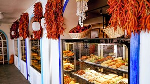 Buffet com diversos alimentos e elementos decorativos, como pimentas vermelhas penduradas e cestos.