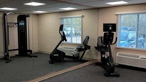 Een sportschool met een pull-up bar, een elliptische machine en een hometrainer.