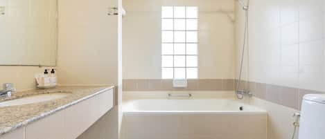 Un baño con bañera, inodoro, lavabo y ventana.