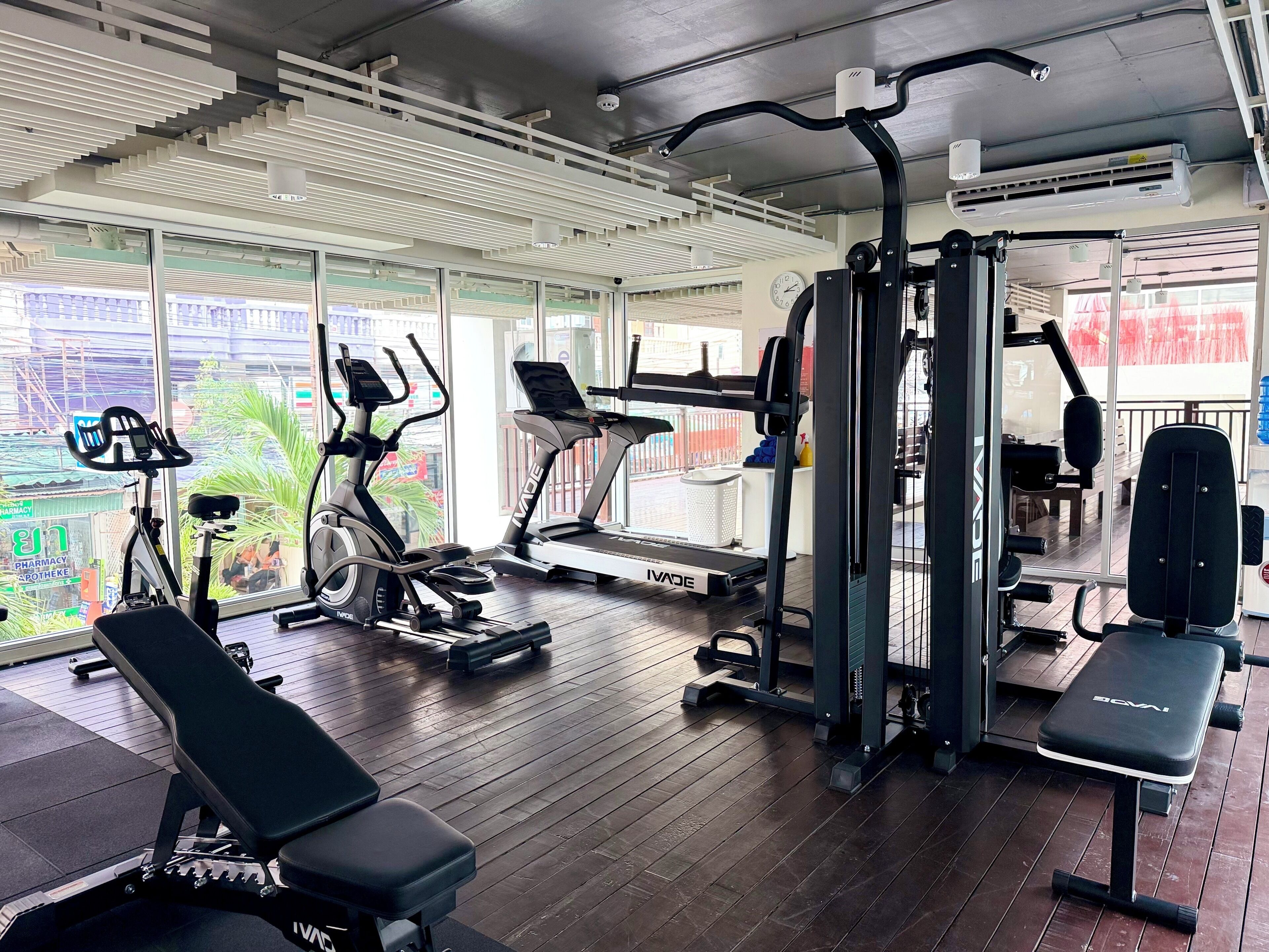 Ein Fitnessstudio mit Cardiogeräten, Gewichten und Bänken.