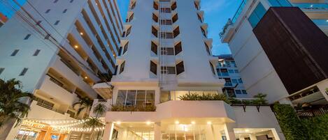 A modern hotel with a central atrium, multiple floors, and a ground-level cafe.