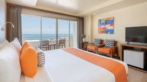A hotel room with a large bed, a television, a desk with chairs, and a balcony with a view of the sea. - Sunshine Hotel And Residences (Pattaya)
