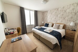 Desk, iron/ironing board, bed sheets