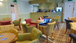 A hotel lobby with a bar area, striped chairs, and a plaid floor. - The Lakeland Kendal Hotel, Sure Hotel Collection by BW (Kendal)
