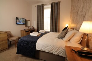 Escritorio, tabla de planchar con plancha, ropa de cama