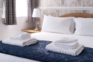 Escritorio, tabla de planchar con plancha, ropa de cama