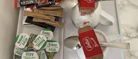 A tray with various food items and drinks, including ice water bottles, a box of biscuits, and several types of milk.