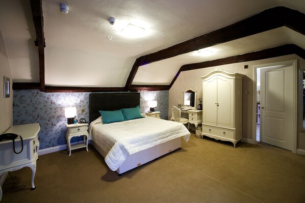A bedroom with a large bed, a desk, a wardrobe, and a door. - Colwick Hall Hotel (Nottingham)