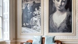 A room with a wooden floor, a wooden sofa with light blue cushions, a glass coffee table, and two large framed paintings on the wall. - Colwick Hall Hotel (Nottingham)