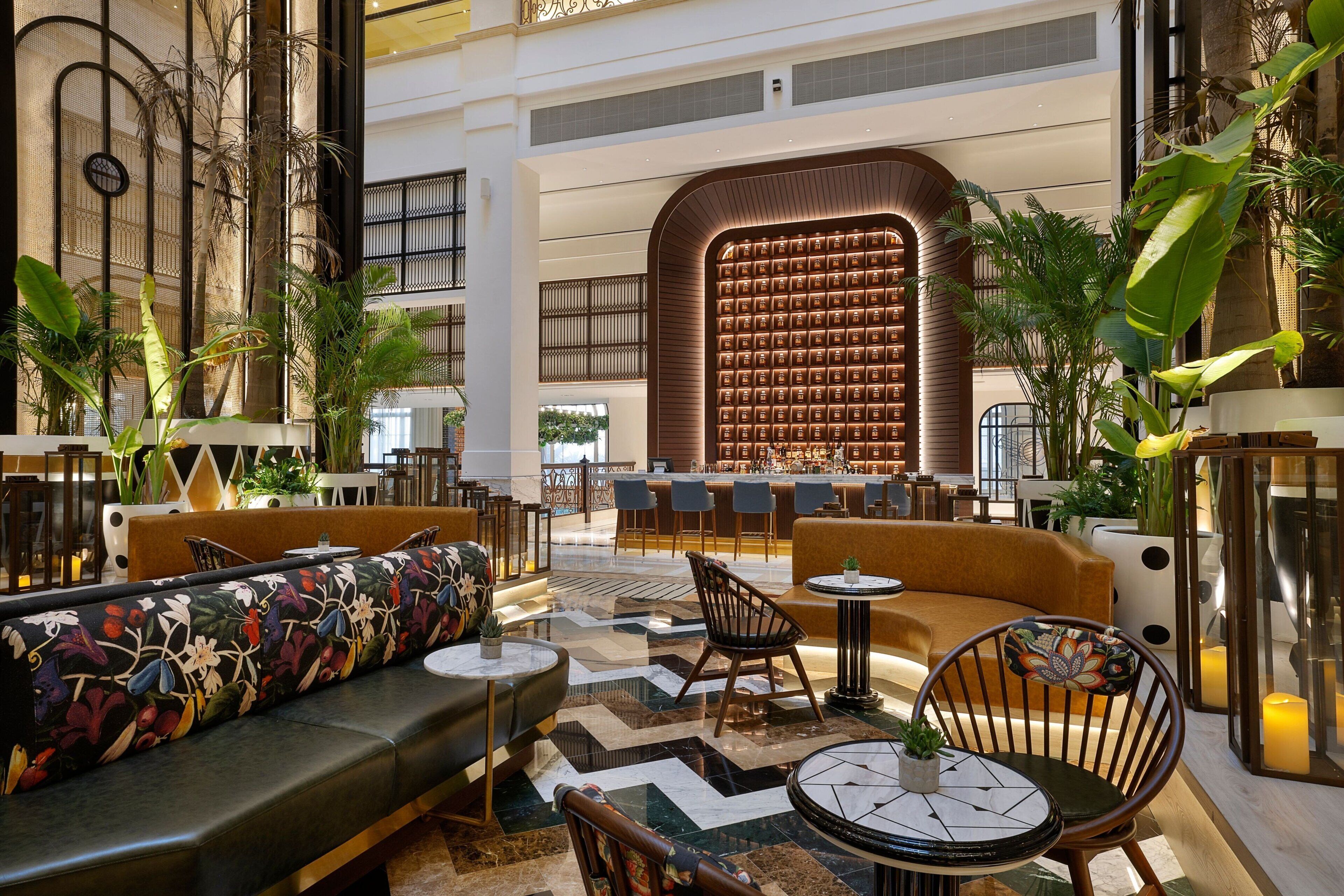 A spacious lobby with a central seating area, a bar, and a large bookshelf.