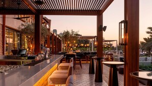 Un área de bar moderna al aire libre con asientos y mostrador.