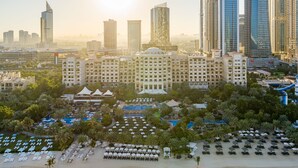 Un hotel con una amplia zona de piscina, diversas opciones de restauración y ubicación frente al mar.