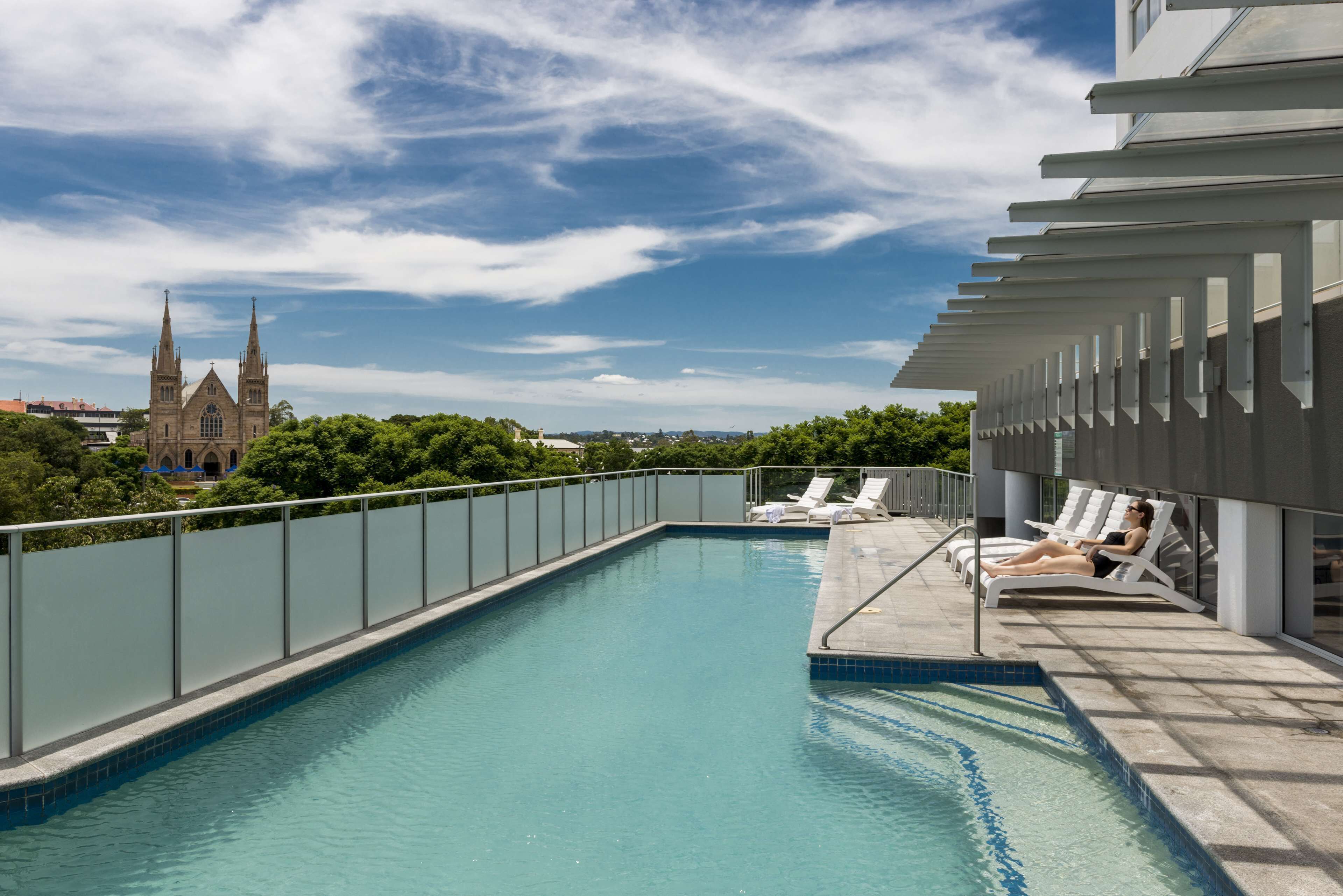Una piscina al aire libre, sillones reclinables de piscina