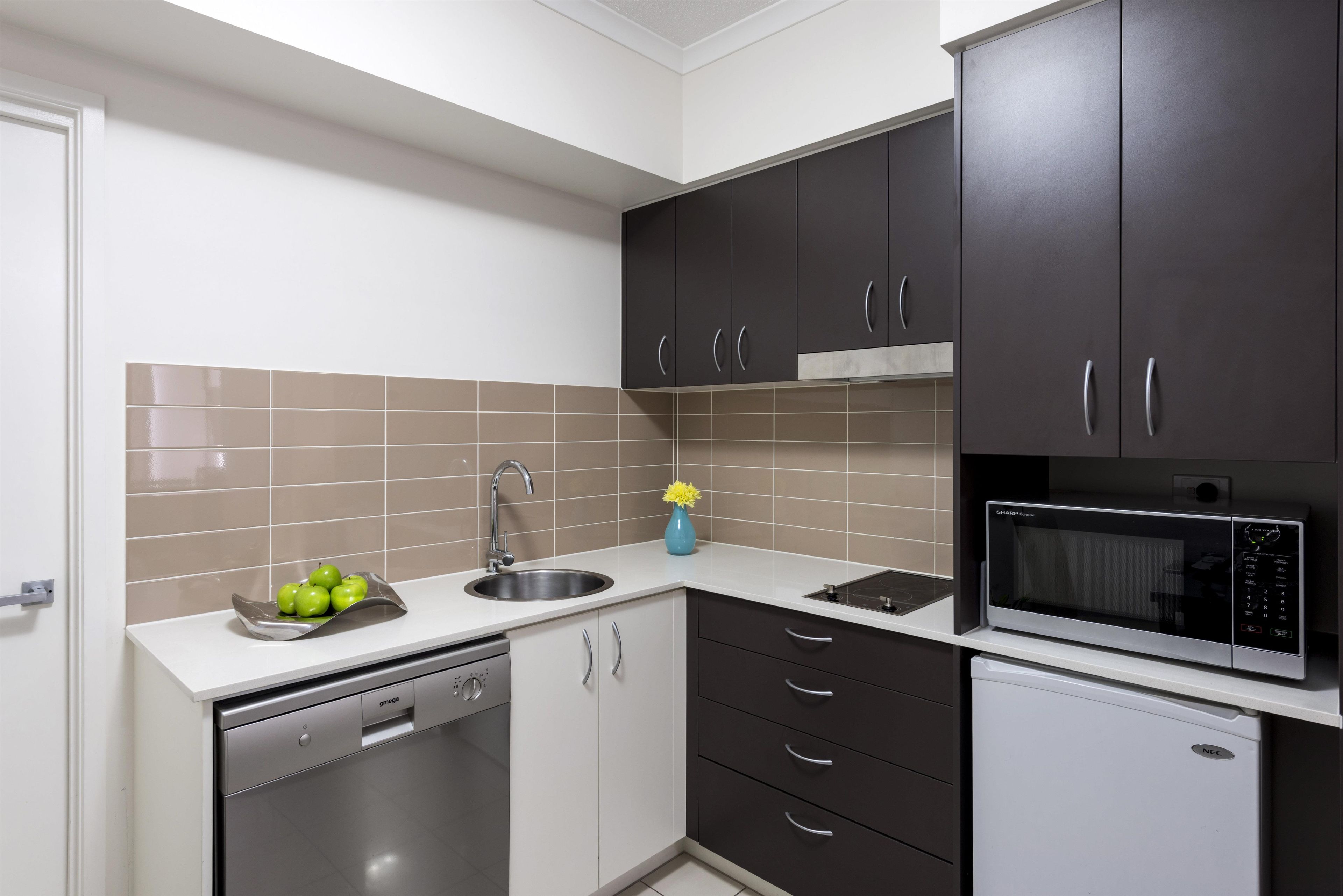 Una cocina moderna con lavavajillas, fregadero y microondas.