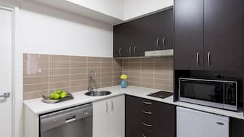 Una cocina moderna con lavavajillas, fregadero y microondas.