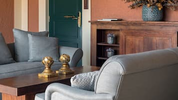 Un salón con un sofá gris, una mesa de centro de madera y una puerta verde.