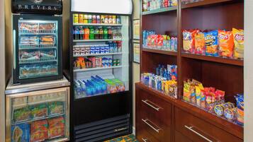 A vending machine with snacks and drinks, a refrigerated display case with food items, and a shelf with packaged goods.