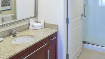Une salle de bain avec deux lavabos, un grand miroir et un espace douche.