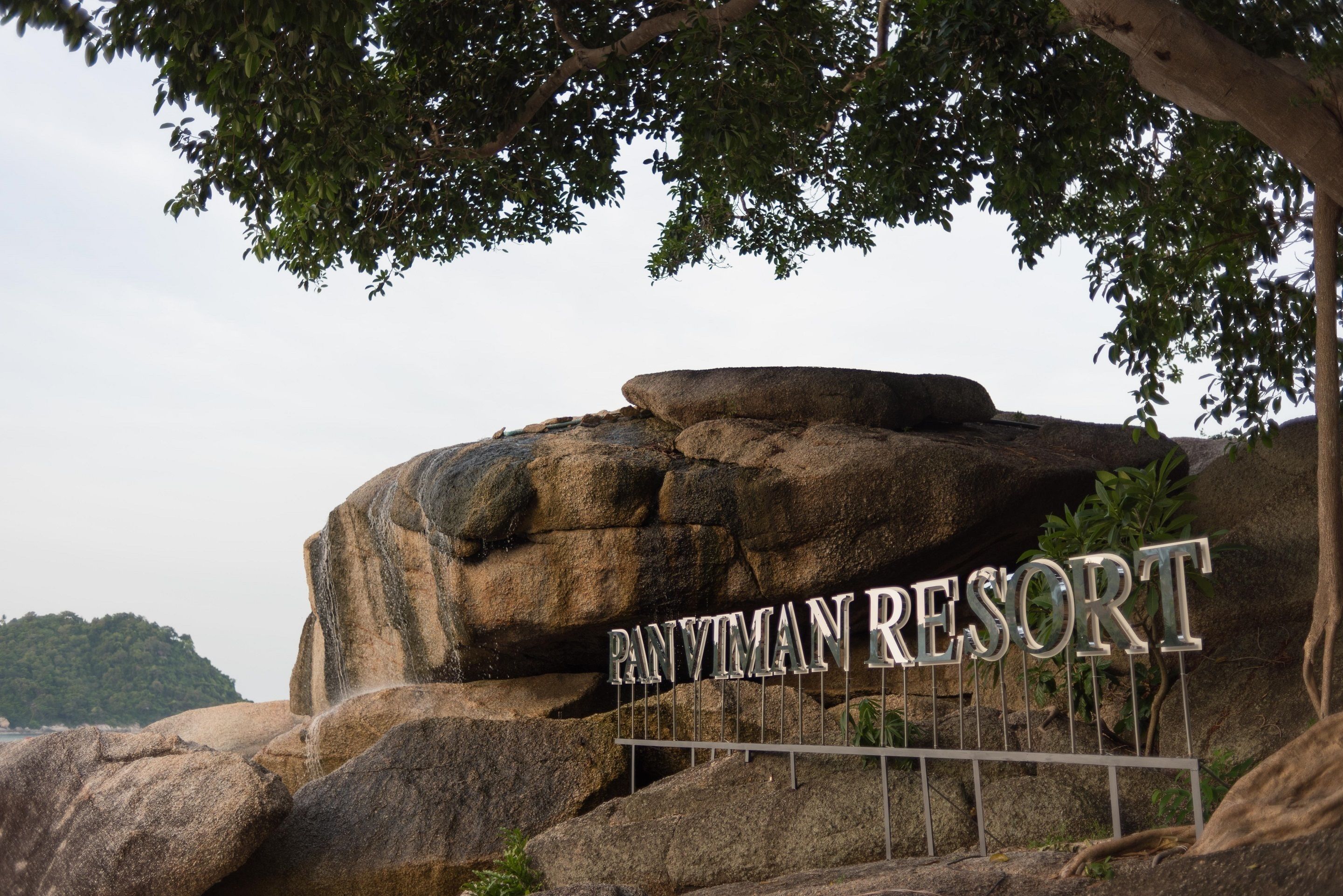 Een grote rotsformatie met de tekst 'PANVIMAN RESORT' erop.