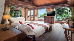 Un dormitorio amplio con una cama grande, televisión y vistas al océano.