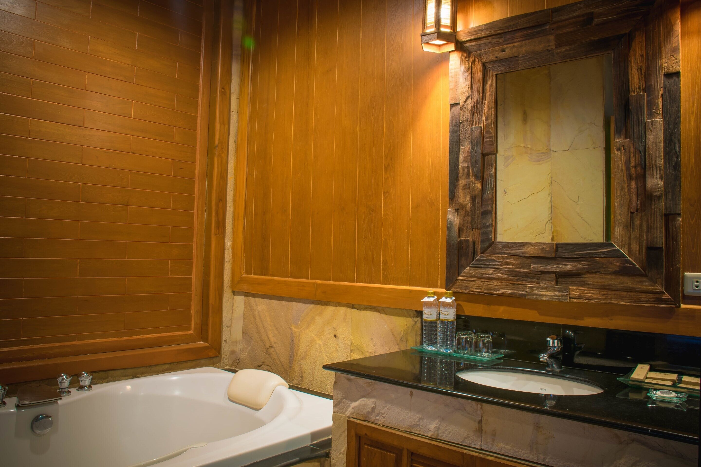 A bathroom with a wooden wall, a marble sink, and a bathtub.