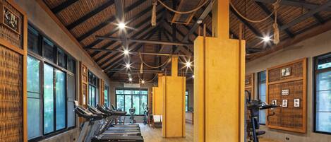 A gym with treadmills, weight benches, and dumbbells.