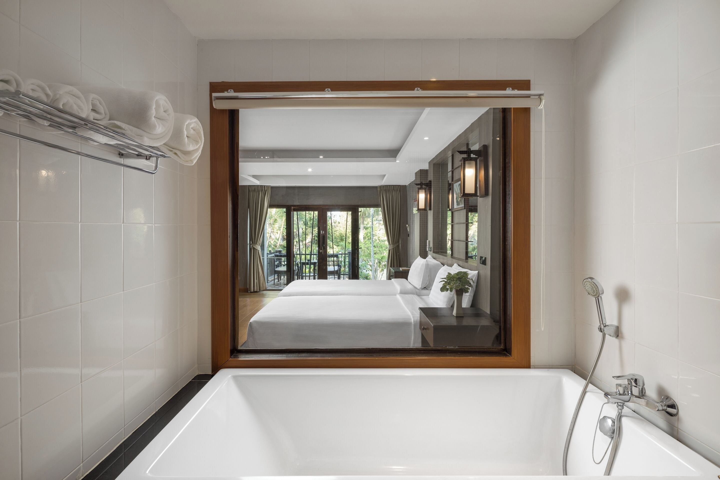 A modern bathroom with a large bathtub, a shower, and a mirror.