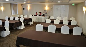 A conference room with tables and chairs, a buffet table with food and drinks, and an exit door. - Holiday Inn Reynosa Zona Dorada by IHG (Reynosa)