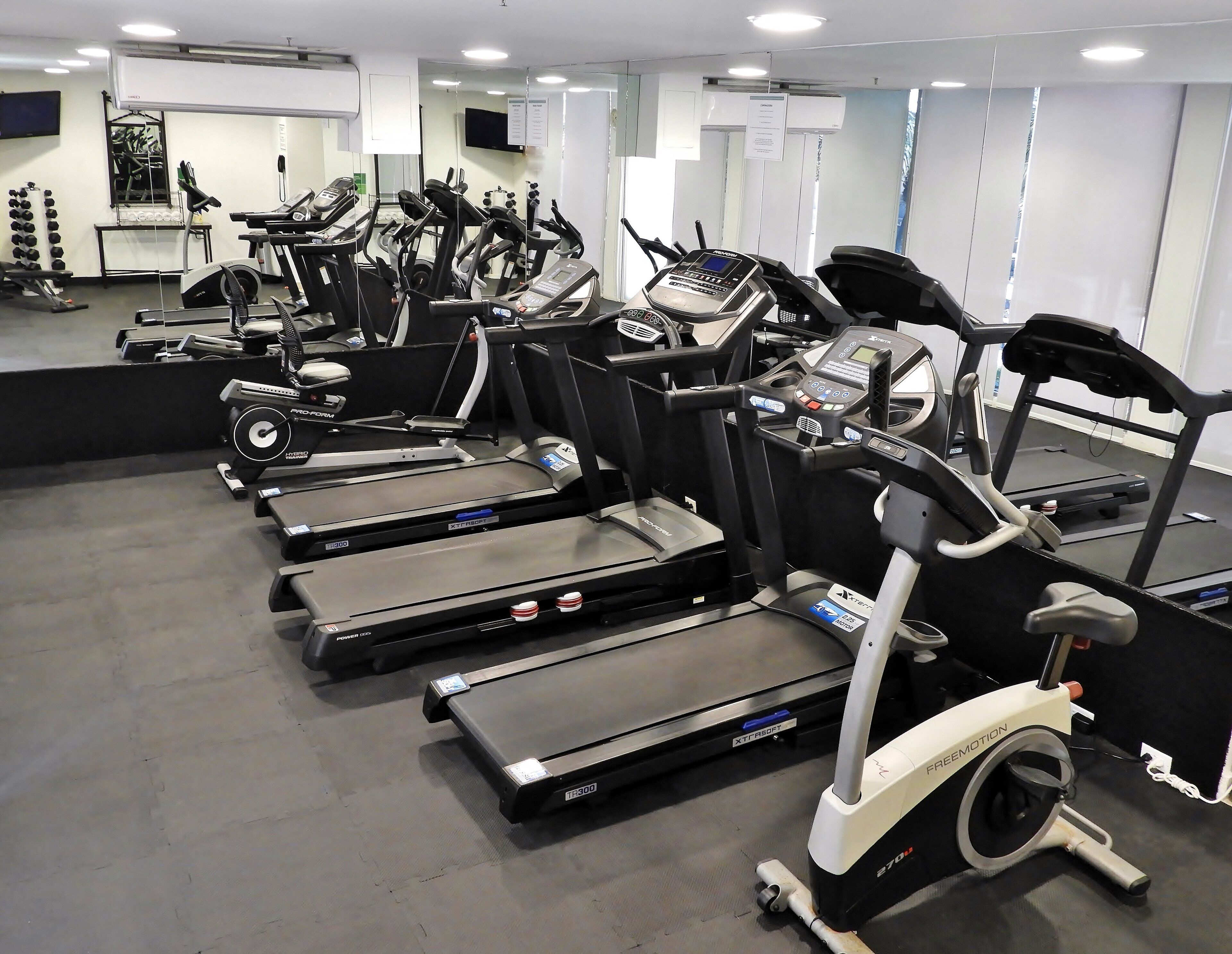 Ein Fitnessstudio mit Laufbändern, Ergometer und Krafttrainingsgeräten.