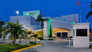 Un hotel con fachada moderna, una entrada destacada y exterior bien iluminado.